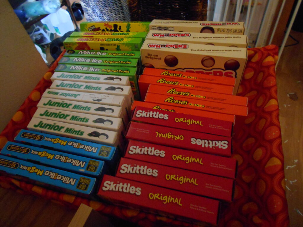 A rectangular orange tray, filled with large-sized tagboard boxes of candy.